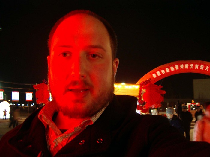 Self-portrait in the red glow of a huge lantern.