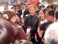 The voice of the people! Fang Di, also known as, "The Radio Man", interviews angry demonstrators outside of a Korla department store. They'd all just lost their jobs because of some sort of swindle. 