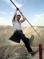 William shows off his physique by hanging over Tiemenguan on a steel cable.