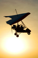 Me, sitting in the back seat and waving, silhouetted against the sun setting over the Taklamakan.