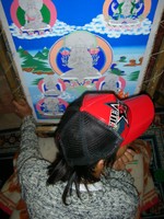 A young thangka painter in Lhasa wearing a Che Guevara baseball cap.