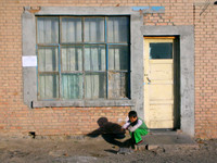 A young girl plays with her pet rabbit in Shimianquan (aka Asbestosville)... the worst place I've ever been in Xinjiang.