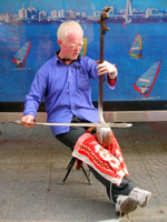 It's not often that you see an albino Chinese man, much less one playing an erhu under the hot sun.