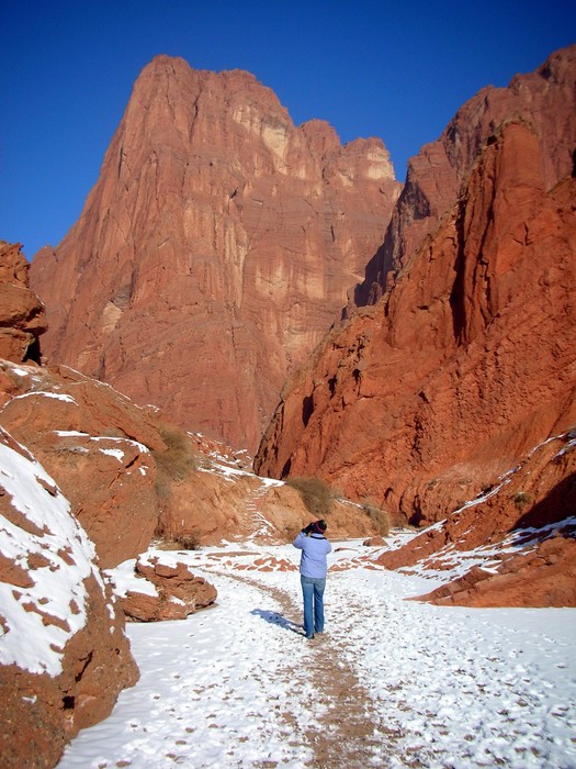 Camilla snaps a photo beneath the read peaks of Kuqa's Mystical Grand Canyon.