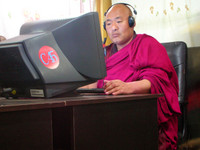 A monk video-conferencing with a friend in one of Xiahe's suprisingly high-quality Internet cafes.