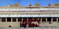 Three photos taken in the courtyard of Labrang's main temple showing 1) two lone monks beginning prayer chants, 2) many monks standing up and entering the temple in response to the blowing of conch shells from above, and 3) the pile of boots left outside when the monks had entered the temple.