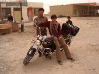 The last small town before the Taklamakan. I stopped to eat a nan bread while these Uyghurs checked out my motorcycle.