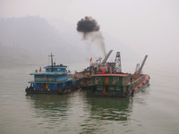 A couple of industrial looking boats float down the Yangzi.