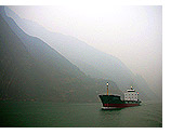 A ship passes through the rising waters of the Three Gorges along the Yangzi River, January 2006.